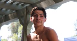 Portrait of a smiling shirtless teenage boy.