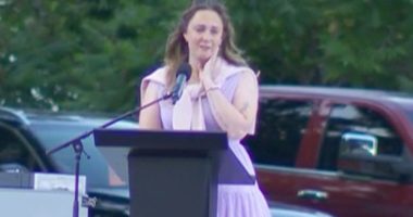Woman crying while speaking at a podium.