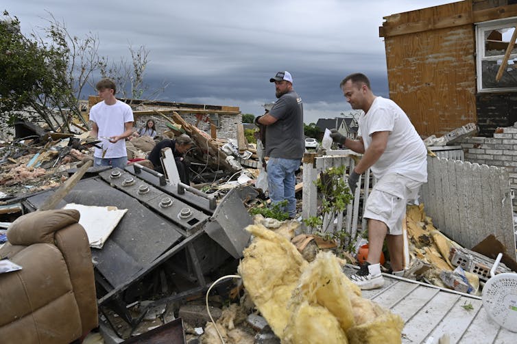 Volunteers help clean up debris from storm damage in the Sunshine Hills neighborhood in London, Ky., Monday, May 19, 2025