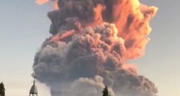 Volcanic eruption plume over a church.