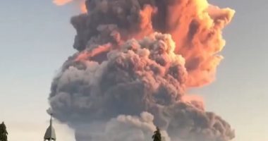 Volcanic eruption plume over a church.