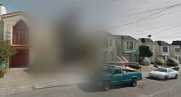 Blurred Google Street View image of houses and a street.