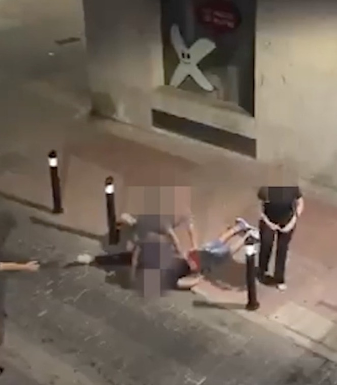A man being restrained on the ground by another man.