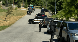 Law enforcement vehicles and officers on a road.