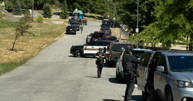 Law enforcement vehicles and officers on a road.