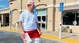 Man in In-N-Out Burger uniform outside restaurant.