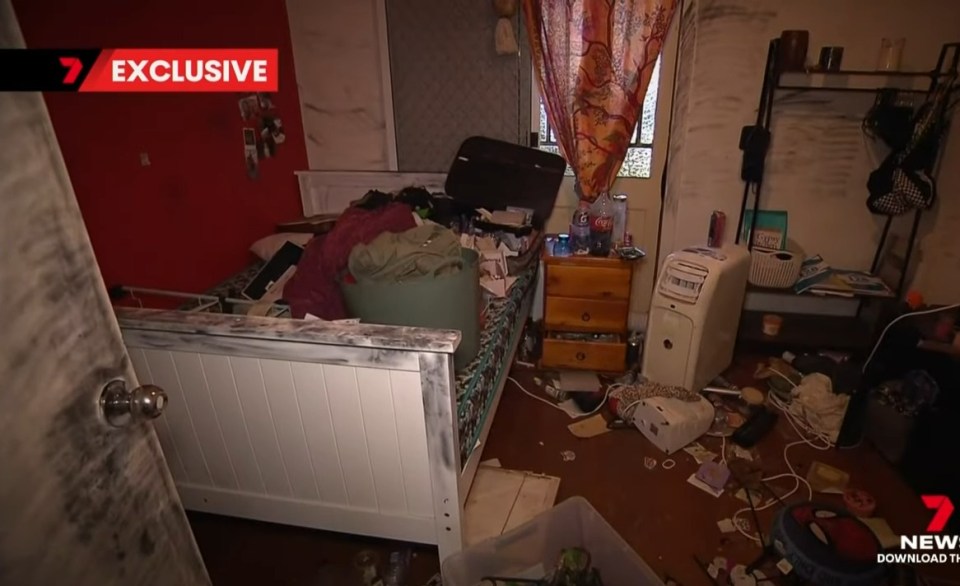 Messy bedroom with belongings strewn across the floor and bed.