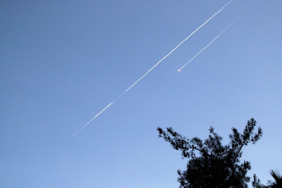 Two Iranian ballistic missiles in the sky.