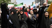 Thousands of Iranians waving flags and protesting.