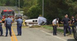 Small plane crash scene on a street near an airport.
