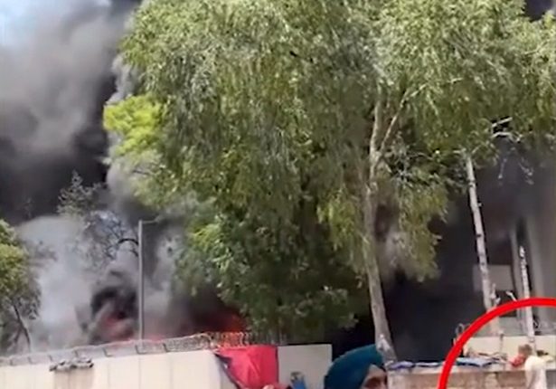 Large fire with people watching from a distance.
