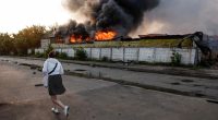 Firefighter at the site of a burning building after a drone strike.