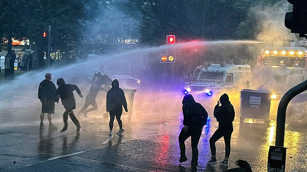 Police use water cannon in response to anti-immigrant violence in Northern Ireland town