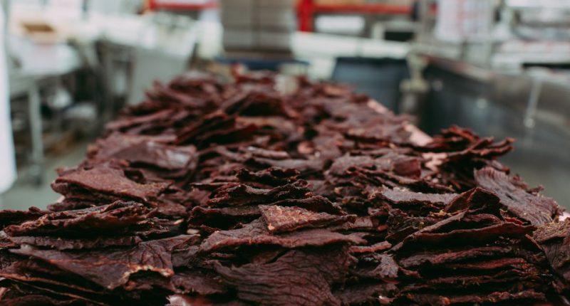 Closeup of a pile of beef jerky in a commercial kitchen.