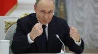 Vladimir Putin gesturing during a meeting with Russian business leaders.