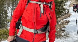 Woman in red jacket hiking in the snow.