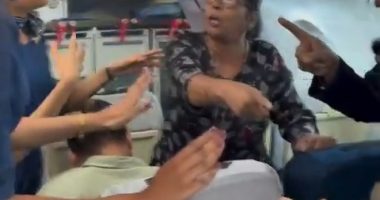 A passenger arguing with flight attendants on an airplane.