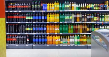 Supermarket shelves stocked with various beverages for sale.