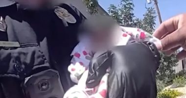Police officer rescuing an emaciated newborn baby.