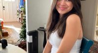 Photo of a smiling young woman sitting at a table.