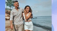 Happy attractive couple walking on beautiful sunny beach. Copy space