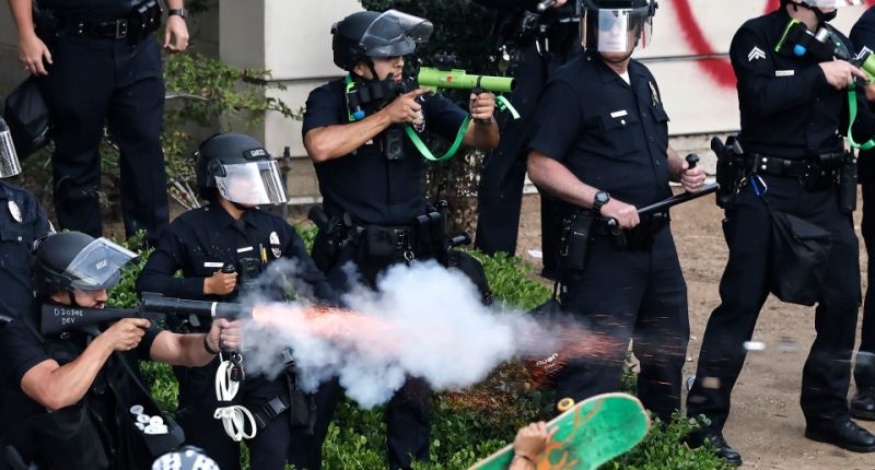 LAPD officers firing less-lethal projectiles at protesters.