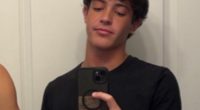A young man taking a selfie in a bathroom mirror.
