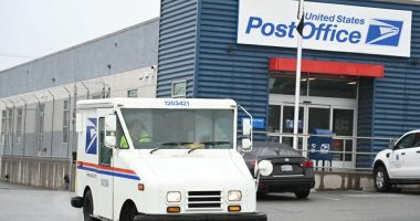 USPS mail truck leaving a post office.