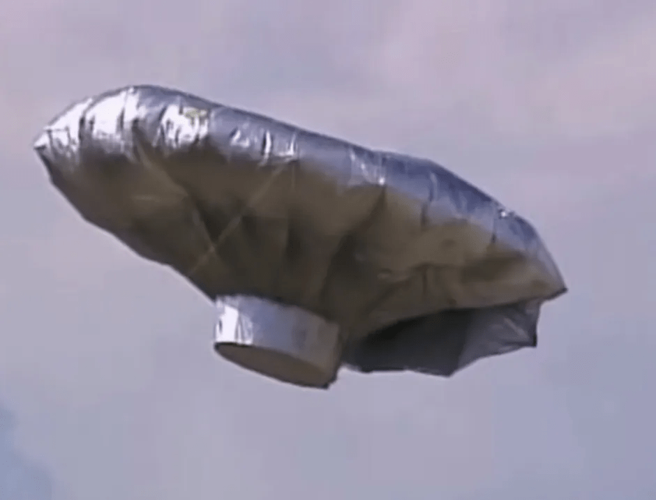 Silver, metallic balloon in the sky.
