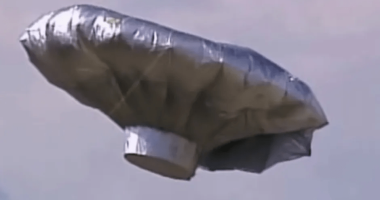 Silver, metallic balloon in the sky.