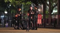 Secret Service officers on bicycles stand guard at a barricade.