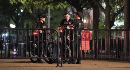 Secret Service officers on bicycles stand guard at a barricade.