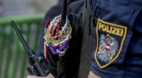 A police officer is decorated with Taylor Swift bracelets while guarding the city centre in Vienna on August 8, 2024.