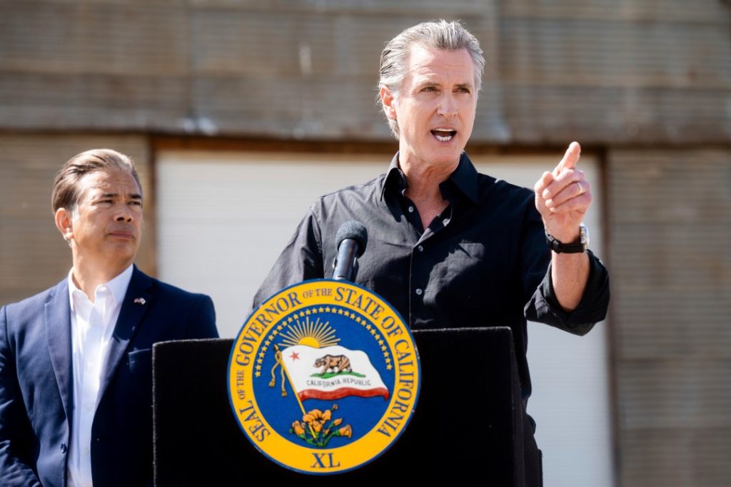 California Gov. Gavin Newsom discusses President Donald Trump's tariffs, as California Attorney General Rob Bonta, left, listens, during a press conference on Wednesday, April 16, 2025, at an almond farm in Ceres, Calif. (AP Photo/Noah Berger)