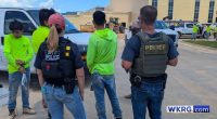 Three detainees wearing neon green shirts in Baldwin County, Alabama