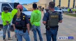 Three detainees wearing neon green shirts in Baldwin County, Alabama