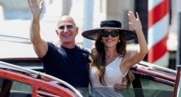 Jeff Bezos and Lauren Sanchez waving from a boat in Venice.