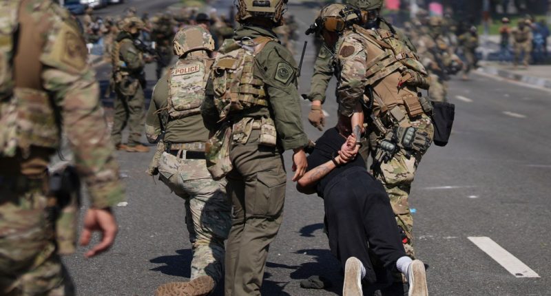 Police detain a man during a protest