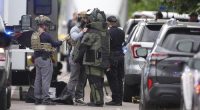 Law enforcement officials dress up in protective gear to investigative an attack on the Pearl Street Mall, Sunday, June 1, 2025, in Boulder, Colo. (AP Photo/David Zalubowski)