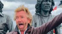 Noel Edmonds spotted once again wearing ODD shoes as he puts on a kooky display while dancing alongside statue of the Bee Gees on the Isle of Man  - ahead of his '£1M' return to TV