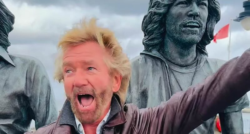 Noel Edmonds spotted once again wearing ODD shoes as he puts on a kooky display while dancing alongside statue of the Bee Gees on the Isle of Man  - ahead of his '£1M' return to TV
