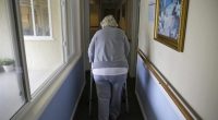 A woman uses a walker as she heads to her room at a senior care home in Calistoga, Calif., on Dec. 5, 2019. (AP Photo/Eric Risberg, File)