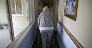 A woman uses a walker as she heads to her room at a senior care home in Calistoga, Calif., on Dec. 5, 2019. (AP Photo/Eric Risberg, File)