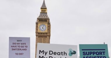 Banners are held by pro-assisted dying campaigners as they gather outside Parliament in London, May 15, 2025