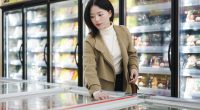 Woman shopping for frozen food in a supermarket.