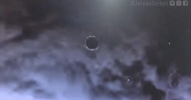 Disc-shaped object in cloudy sky.