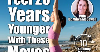woman standing on rocks by the sea meditating and practicing yoga, arms above head, 5 Simple Standing Exercises That Make You Feel 20 Years Younger, Cover