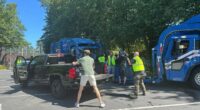 Residents loading garbage bags into a pickup truck during a garbage collection disruption.
