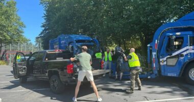 Residents loading garbage bags into a pickup truck during a garbage collection disruption.