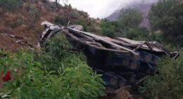 Wrecked bus on a hillside.